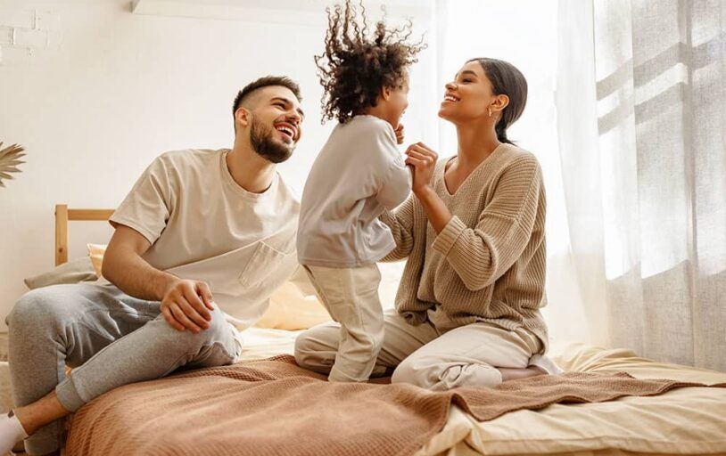 Family of three on bed