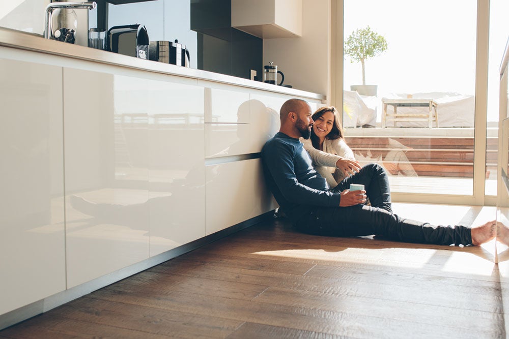 Couple sitting on the floor in kitchen