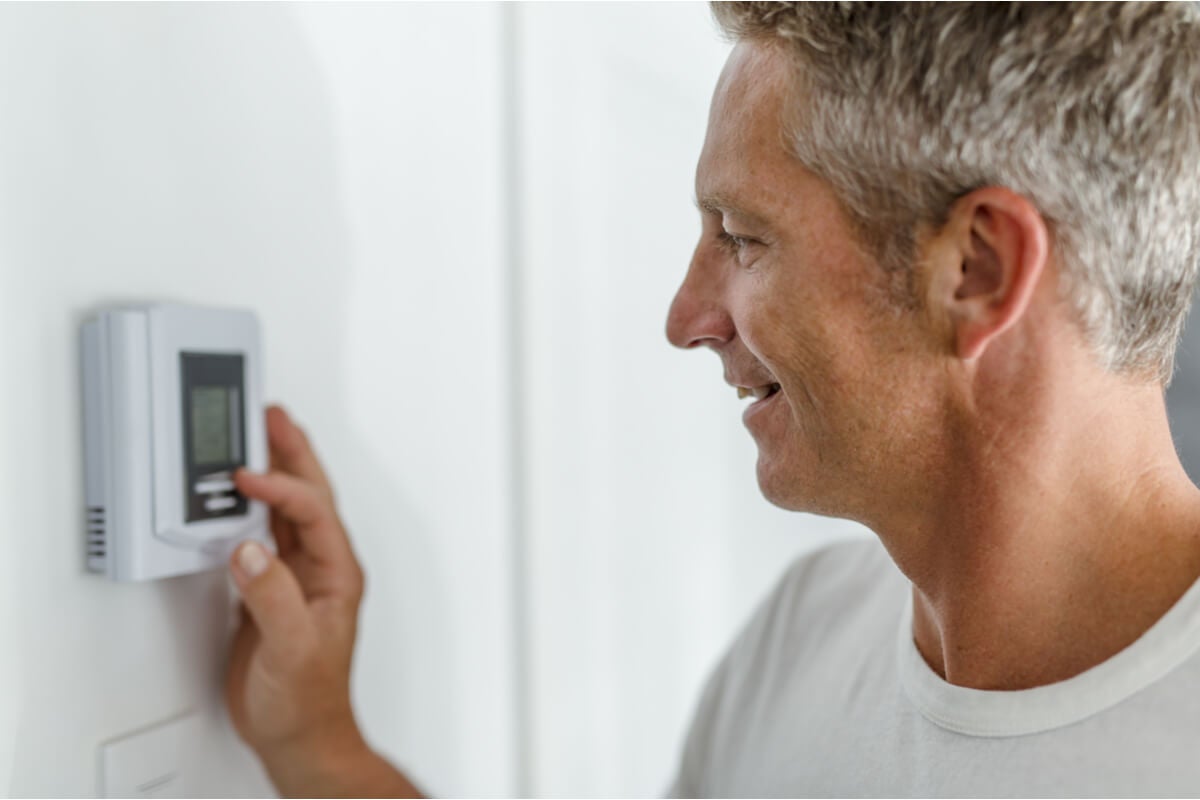 Man adjusting thermostat