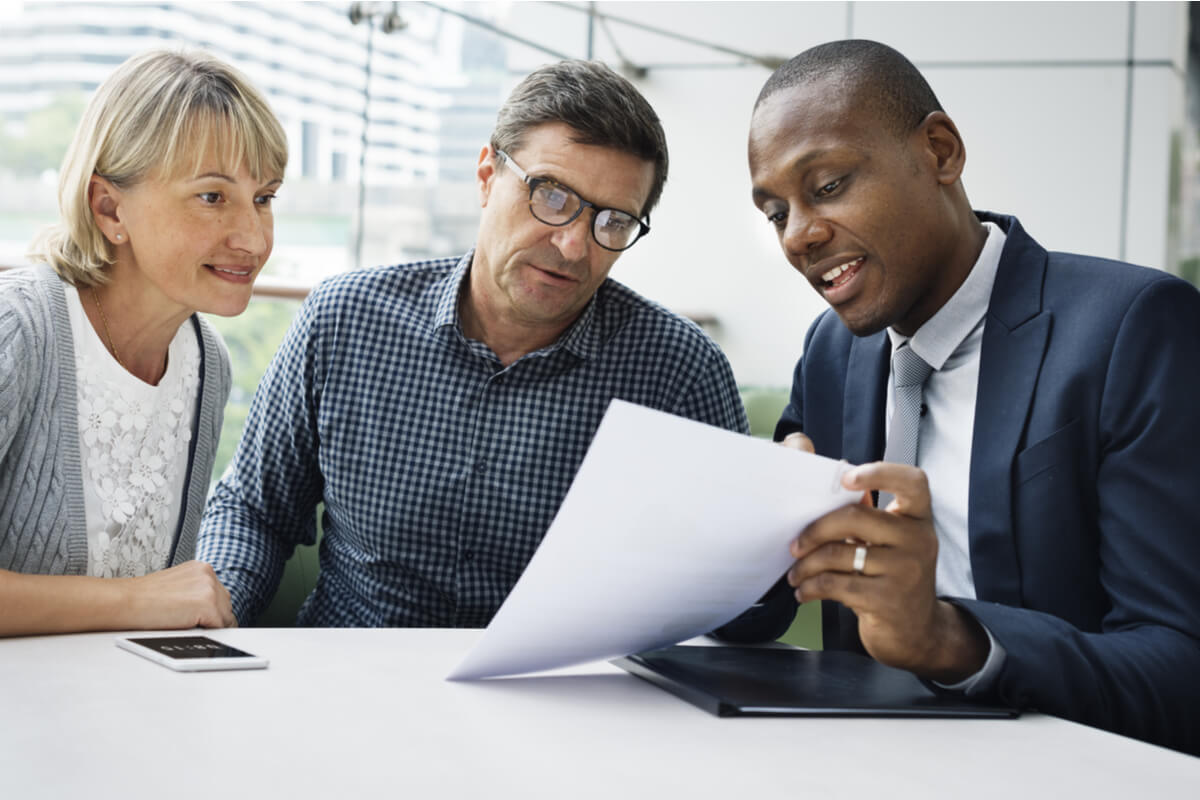 Three people at a table with a document