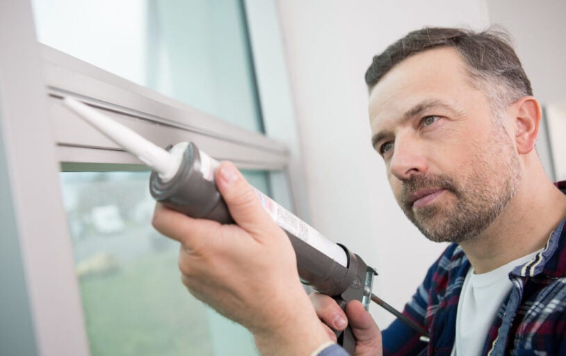 Man caulking his window