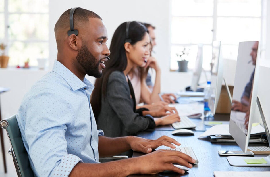 People With Headsets Using Computer