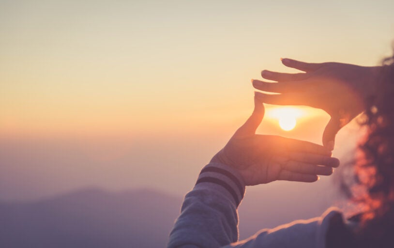 Hands framing a sunset