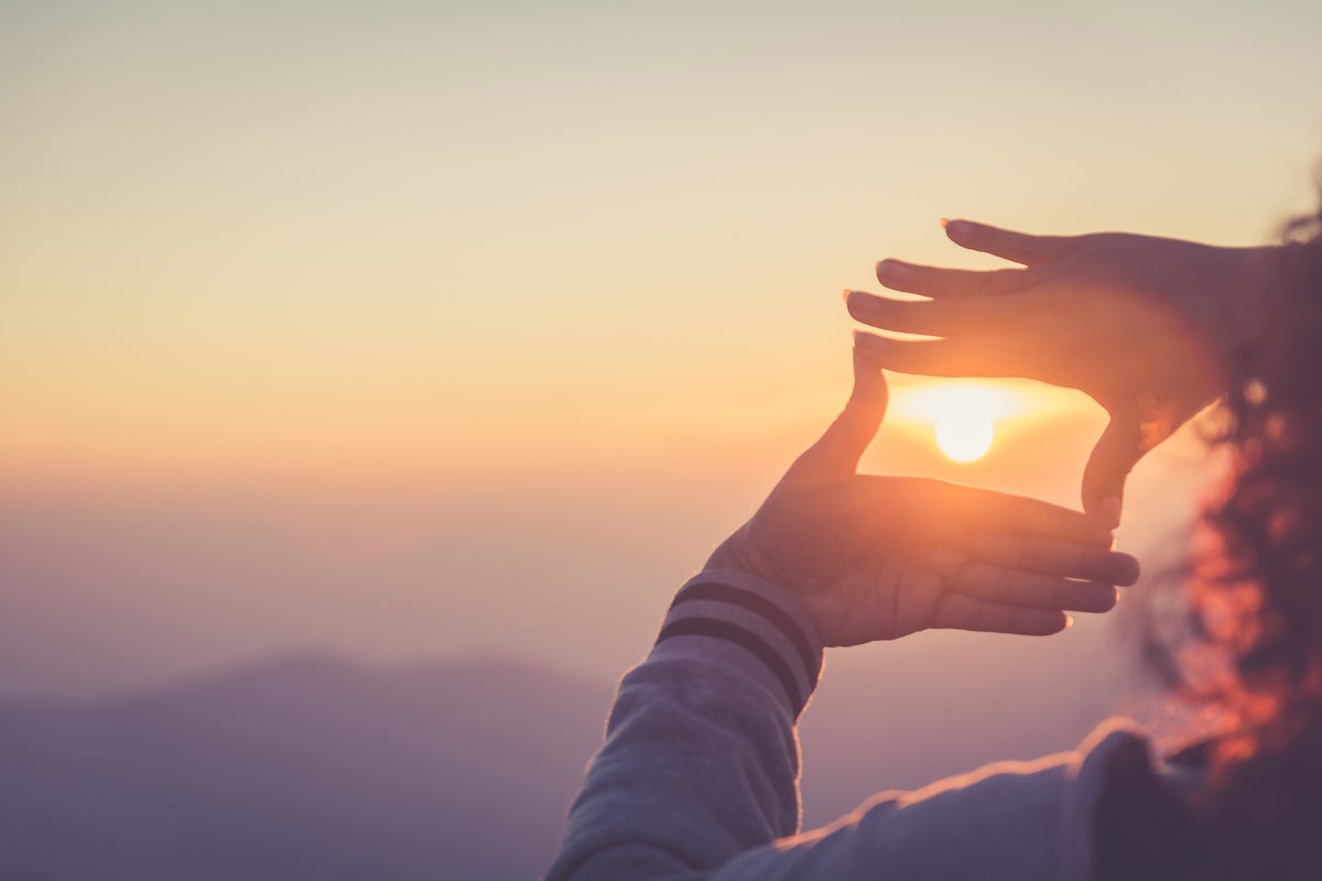 Hands framing a sunset