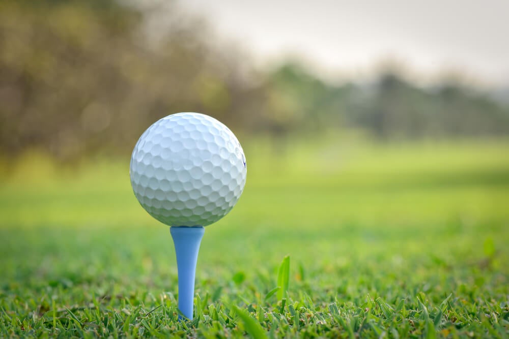 Golf ball on a golf tee on a golf course