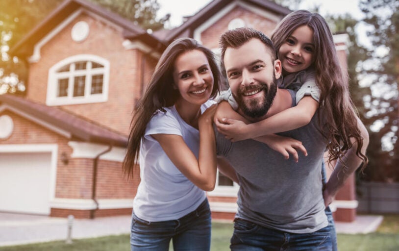 Happy family in front of house