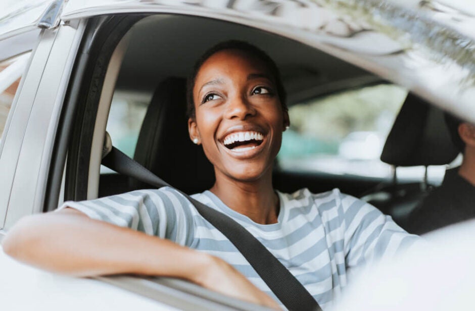 smiling woman in drivers seat of car