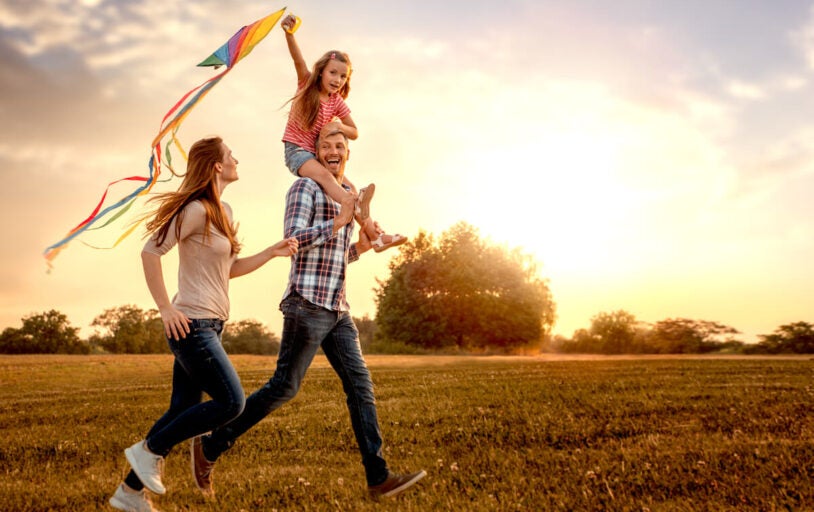 Family in field flying a kite