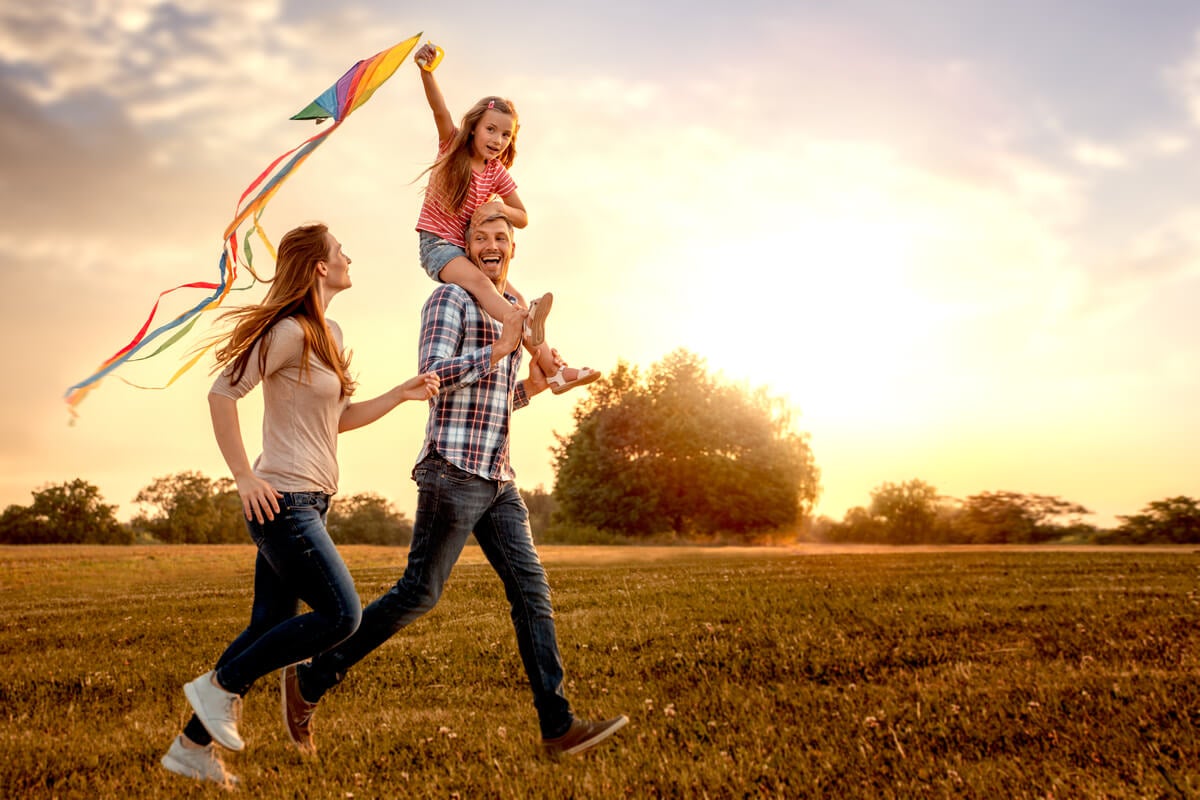 Family in field flying a kite
