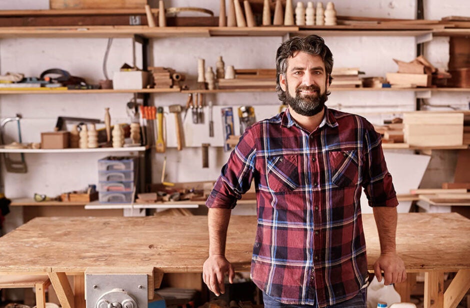 Man with a beard standing in wood working workshop