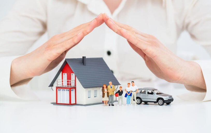 Model of home, family, and car covered with hands