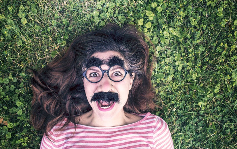 Woman laying in grass with funny glasses on