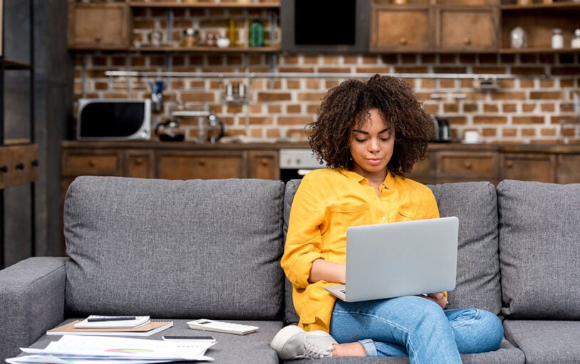 Woman working on laptop on couch