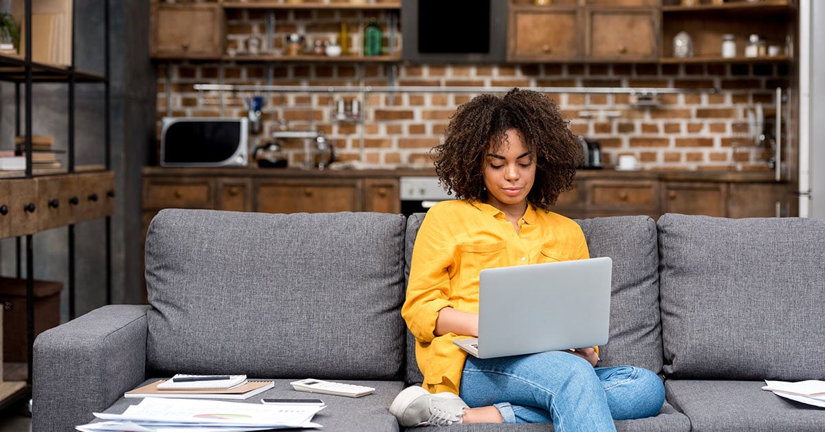 Woman working on laptop on couch