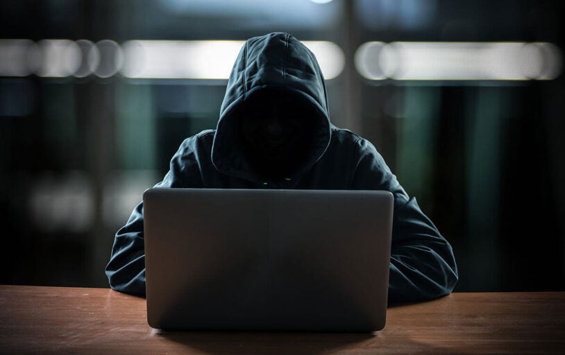 Hooded man at laptop