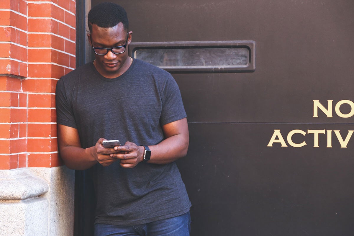 Man leaning against a wall on his cellphone