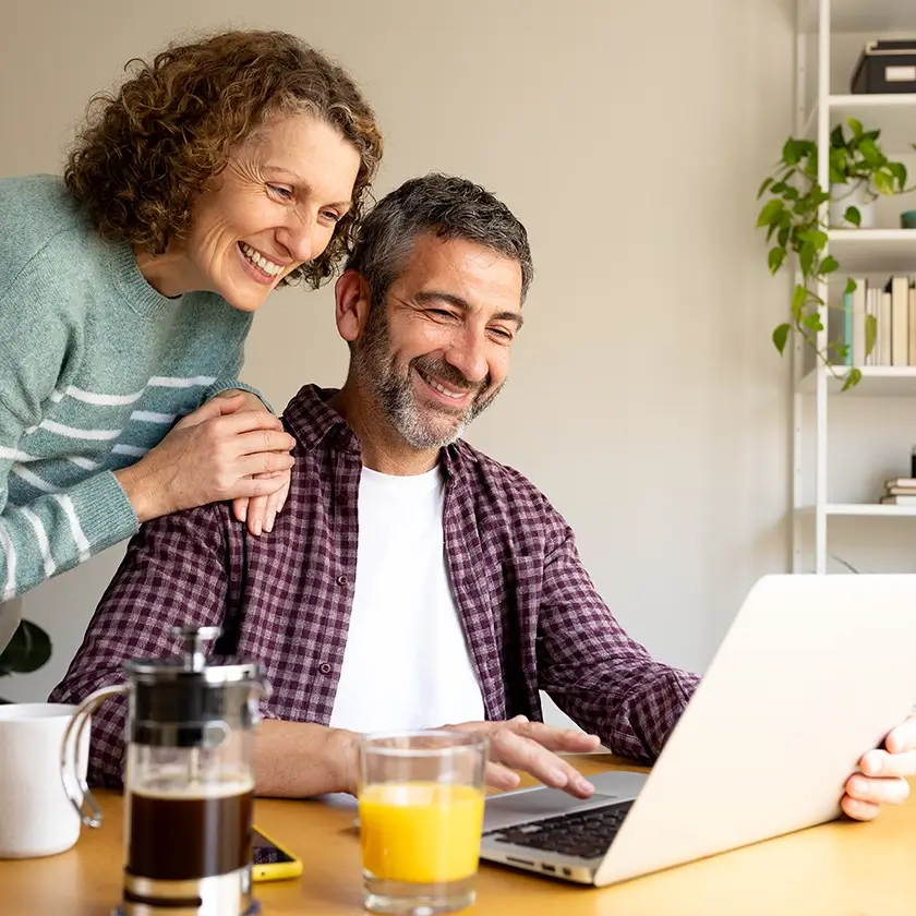 Money Market. Couple looking happily at laptop